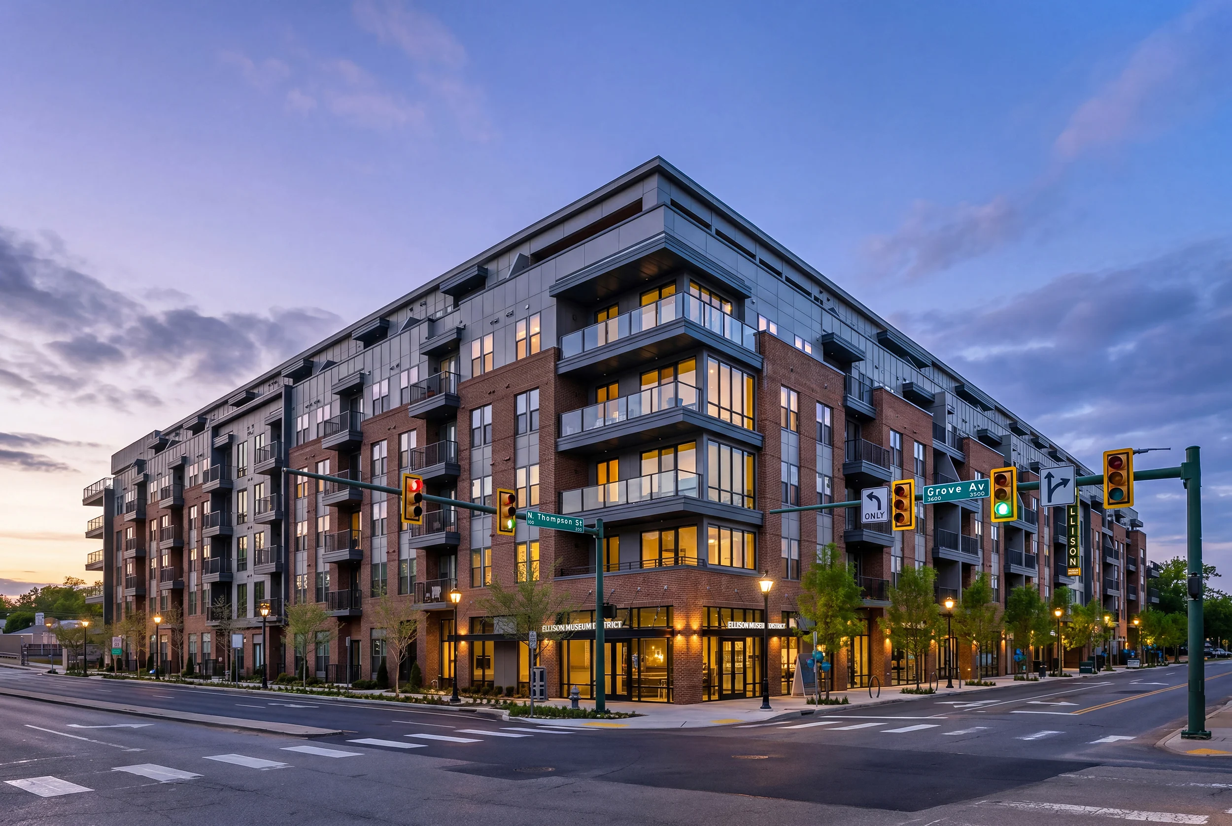 Modern Apartment Building at Dusk A modern apartment building at dusk, featuring brick and glass architecture, located at a street intersection with traffic signals and landscaped sidewalks.
