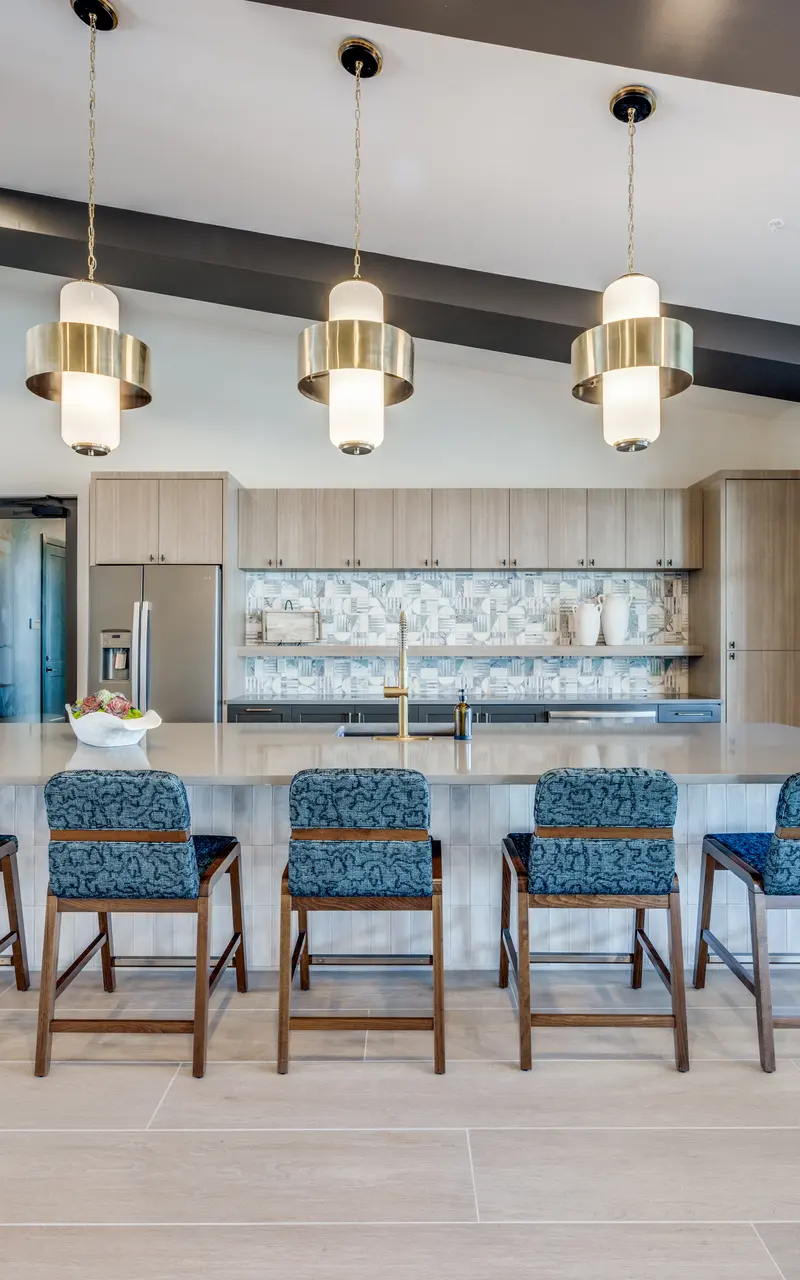 Stylish Modern Kitchen Interior A modern kitchen interior featuring a large island with seating, stylish pendant lights, and contemporary cabinetry. Large windows and decor elements create a bright and inviting atmosphere.