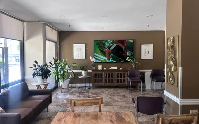 Community Lounge Area A community lounge area featuring a television, plants, seating, and a dining table.