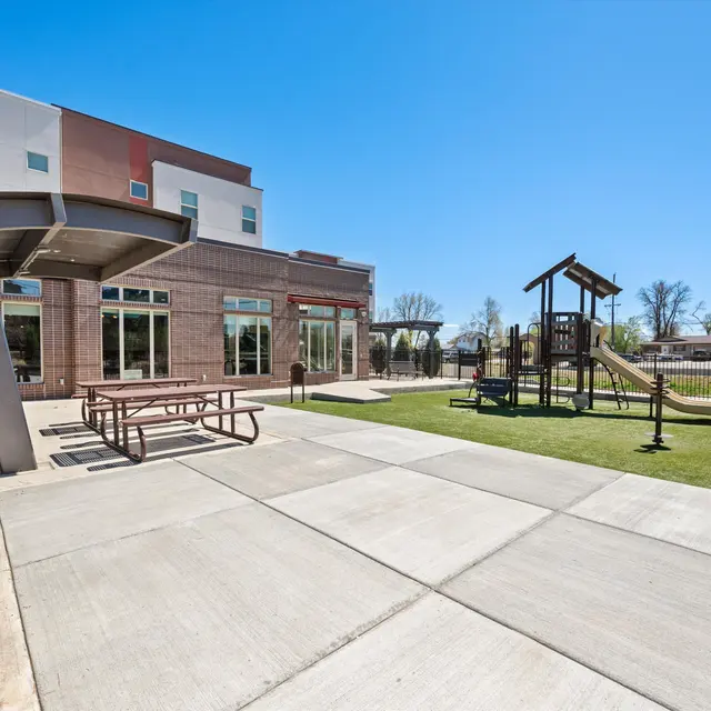Playground with picnic tables and a playset at Baker School Apartments in Berkley, Colorado.