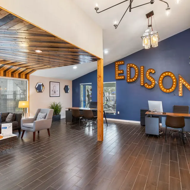 Stylish Office Reception Area A modern office reception area featuring a comfortable seating area, wooden decor, and a prominent wall displaying the word 'EDISON' in lights.