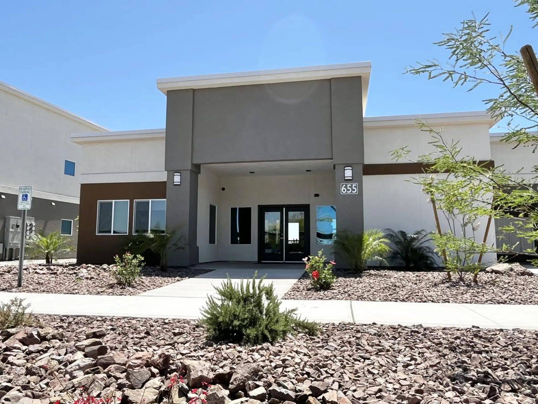 Glass-door entrance marked 655 beside gravel landscaping.