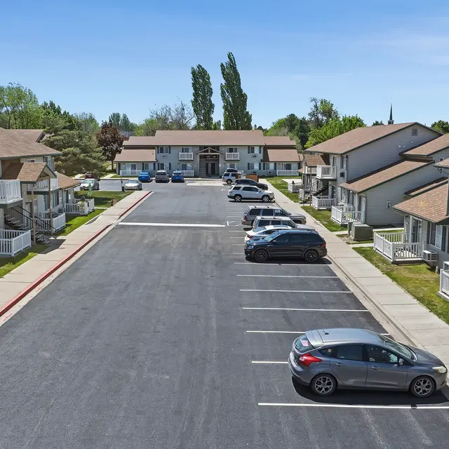 Residential Apartment Complex Aerial view of a residential apartment complex with two-story buildings lining both sides of a parking lot.