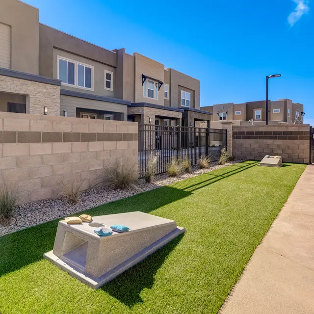Town Germann - Exterior An outdoor area featuring artificial turf, concrete pathways, and several apartment buildings in the background.