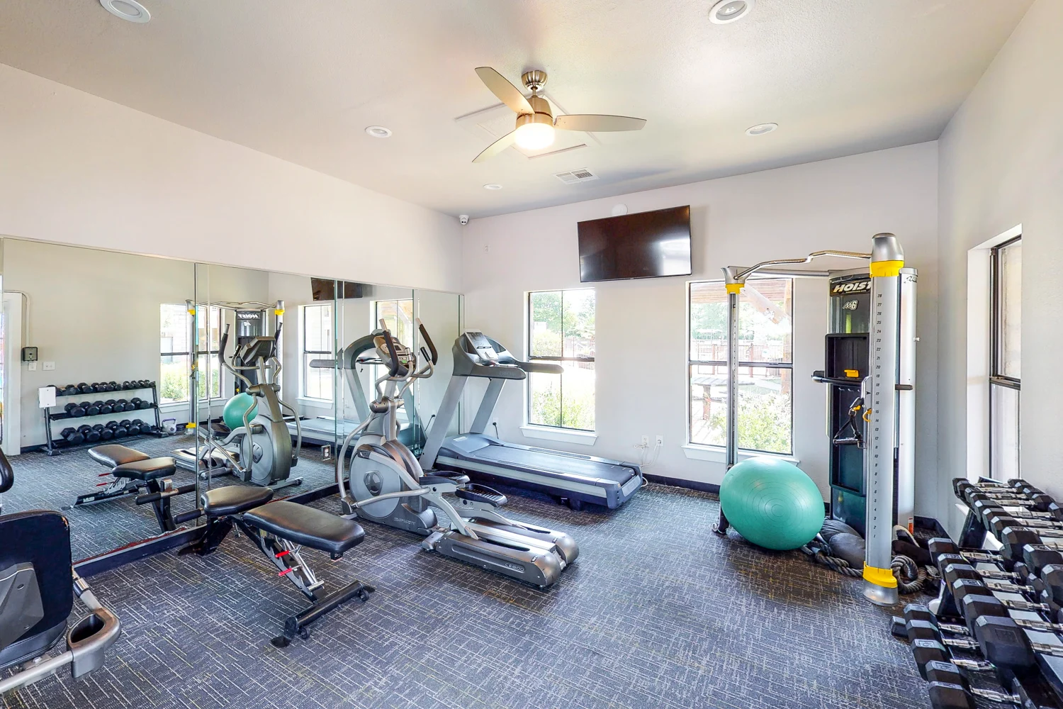 Modern Gym Interior A well-equipped gym with exercise machines, free weights, and large mirrors.