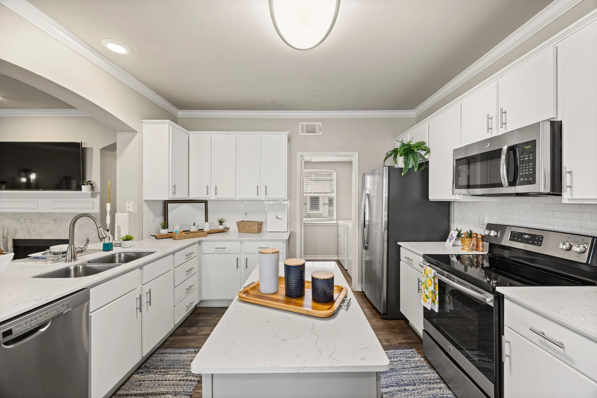 Modern Kitchen Interior A modern kitchen featuring white cabinets, stainless steel appliances, and a central island with decorative items on it.