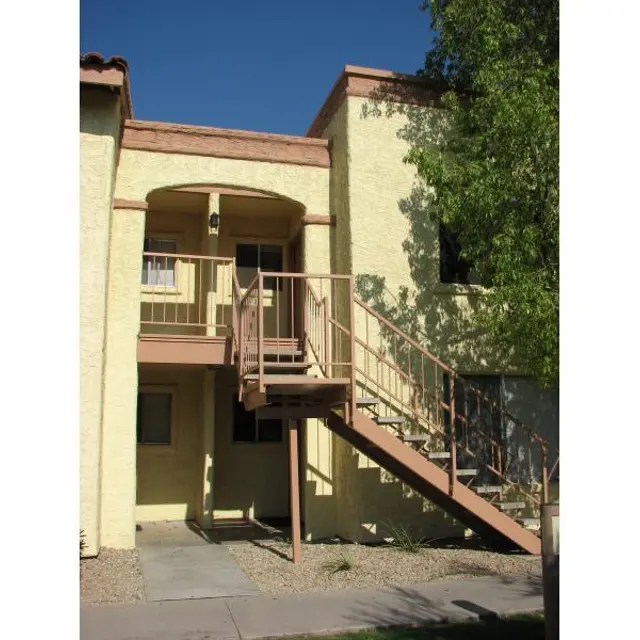 Two-Story Apartment Building Exterior view of a two-story apartment building with a staircase leading to the second floor.