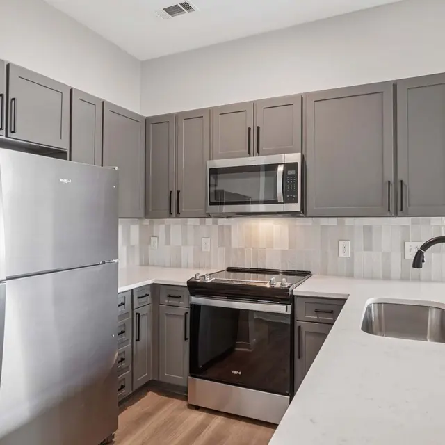 Modern Kitchen Interior Contemporary kitchen featuring gray cabinets, stainless steel appliances, and a white countertop.