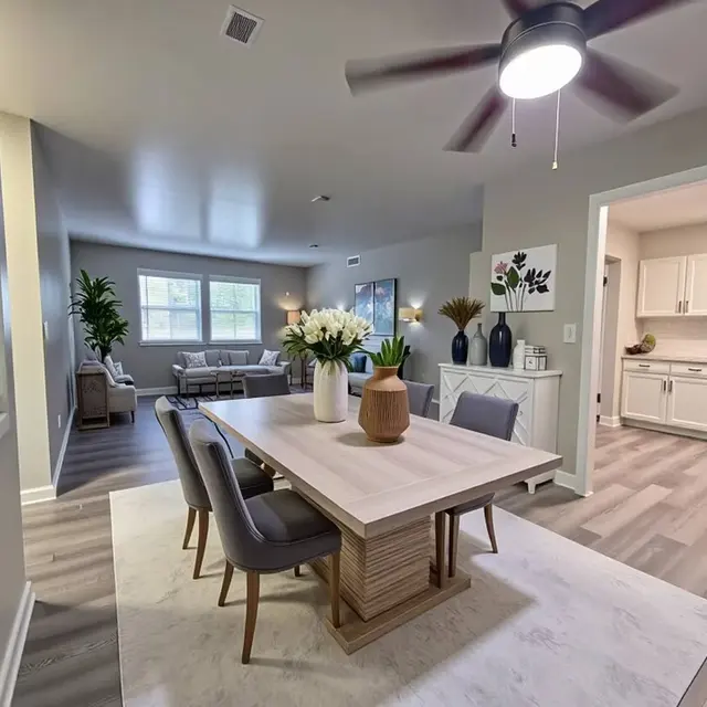 Modern living space featuring a dining table with chairs, indoor plants, and an open kitchen area with neutral tones.
