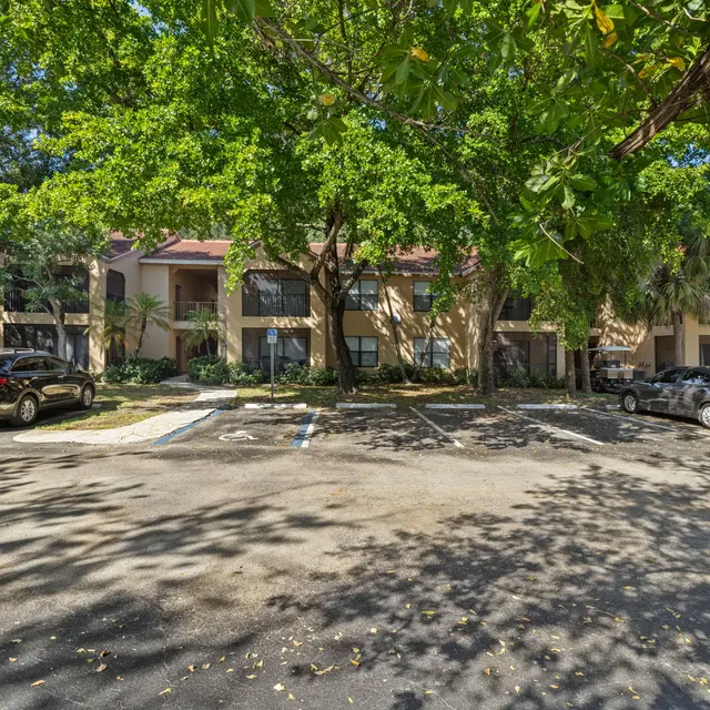 Parking area of an apartment complex surrounded by trees.