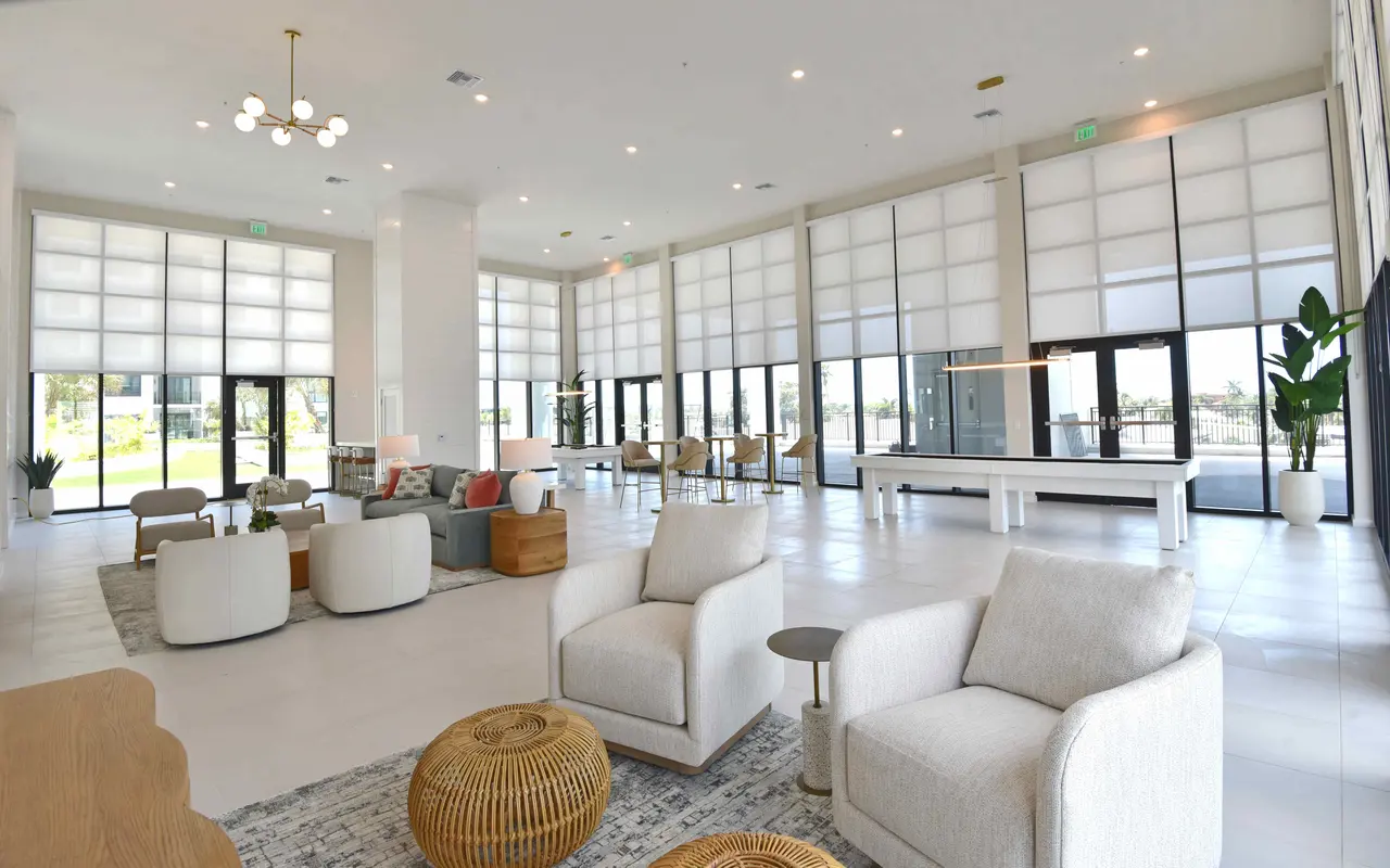 A spacious modern lobby featuring large windows, comfortable seating areas, and minimalist decor.