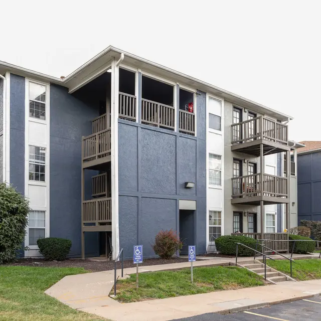Exterior view of a modern apartment complex with blue siding and balconies