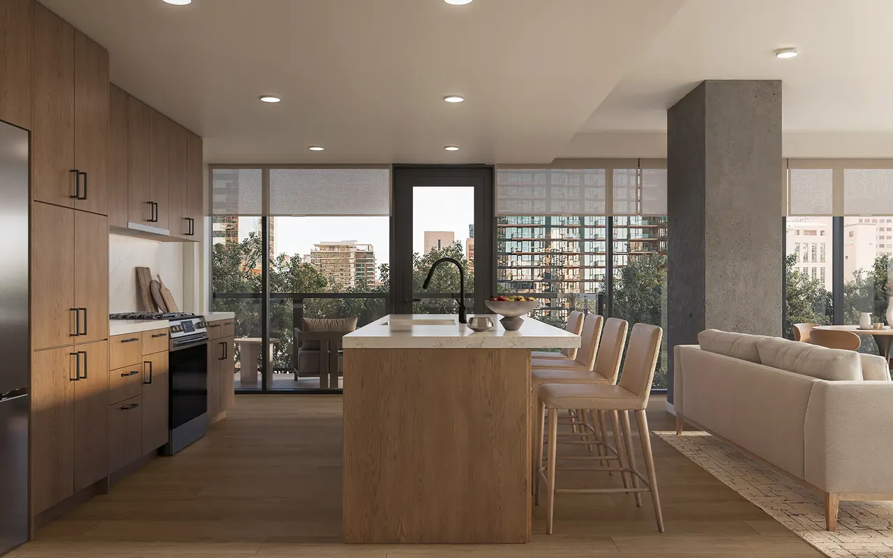 A modern kitchen featuring wooden cabinets, a central island with bar stools, and large windows letting in natural light.