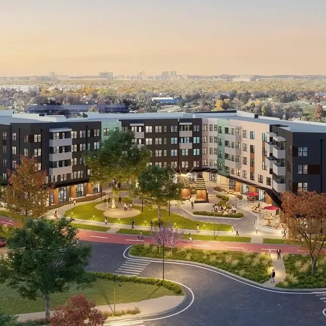 Aerial view of a modern apartment complex with landscaped greenery, pathways, and recreational areas.