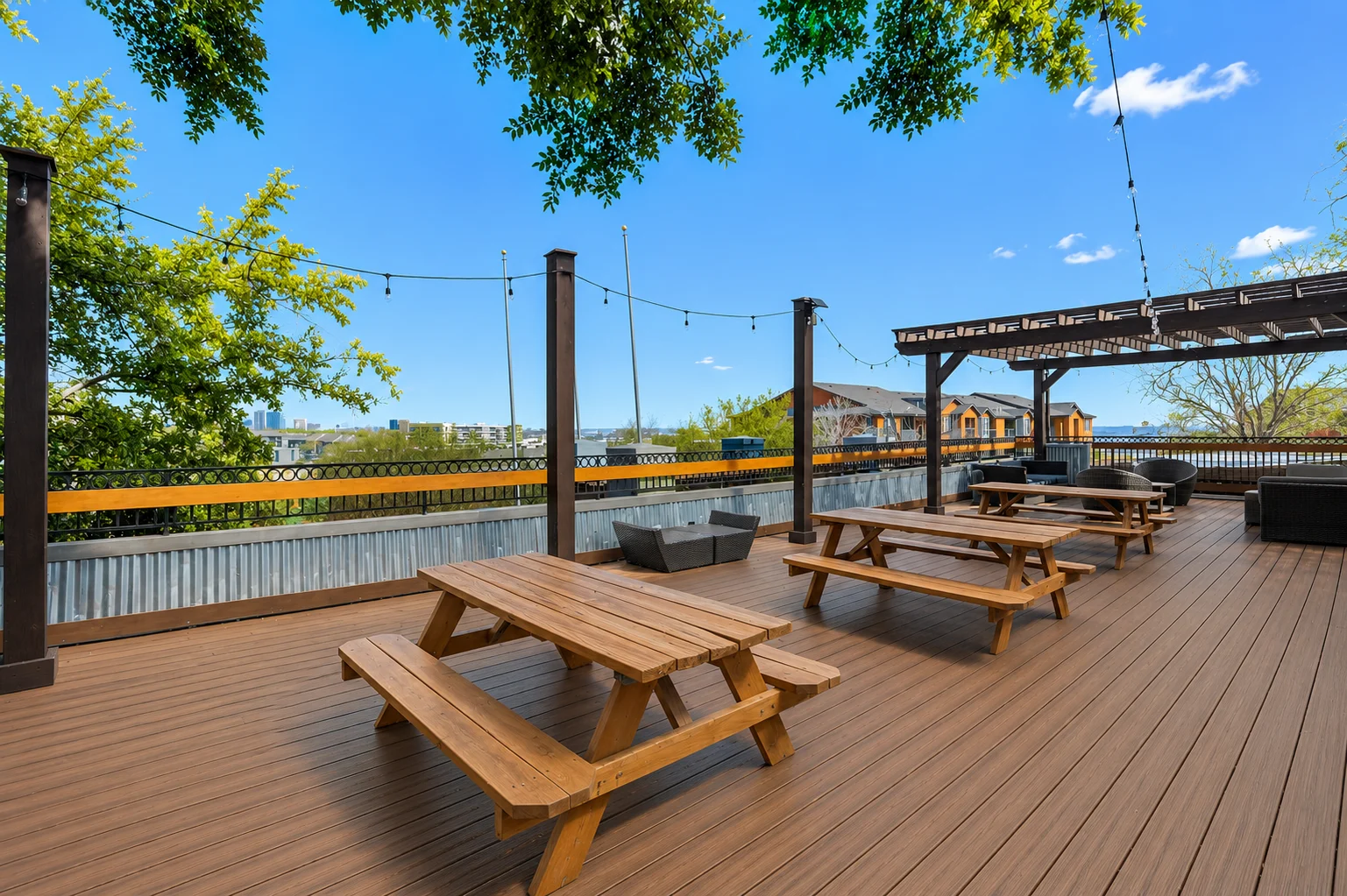Outdoor Deck with Seating Spacious outdoor deck with wooden picnic tables and ambient lighting.