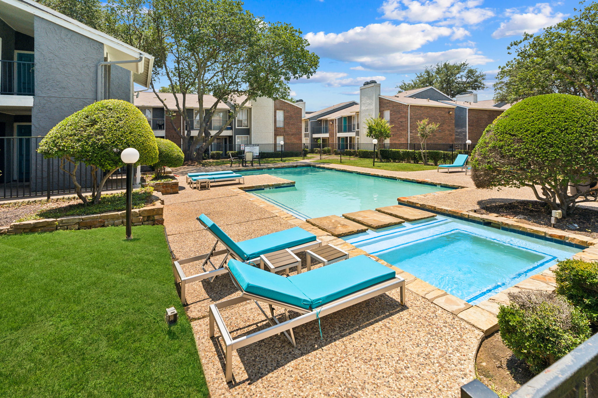 Apartment Complex Pool Area Swimming pool area in an apartment complex with lounge chairs and landscaping.