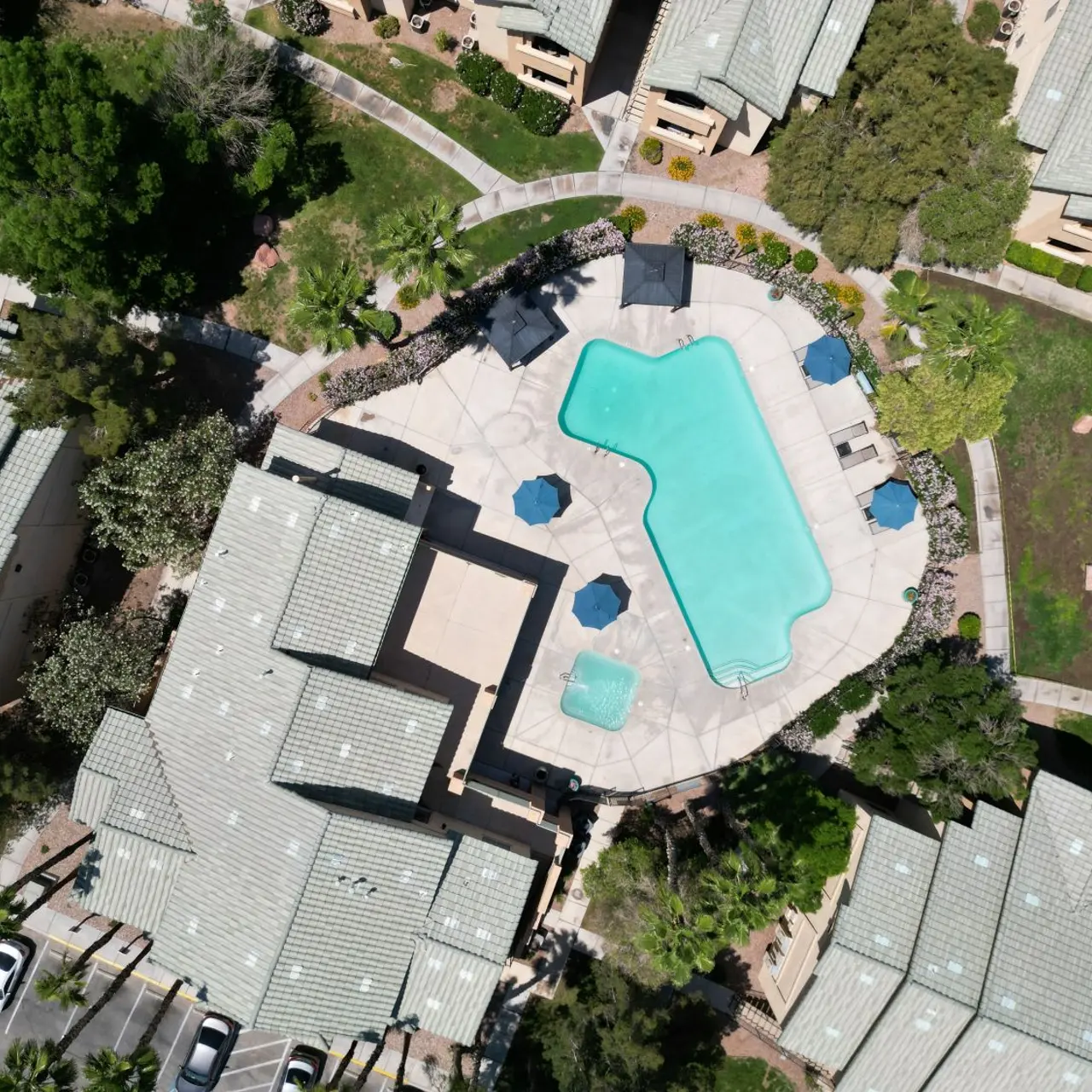 Aerial view of a swimming pool surrounded by apartment buildings and greenery.