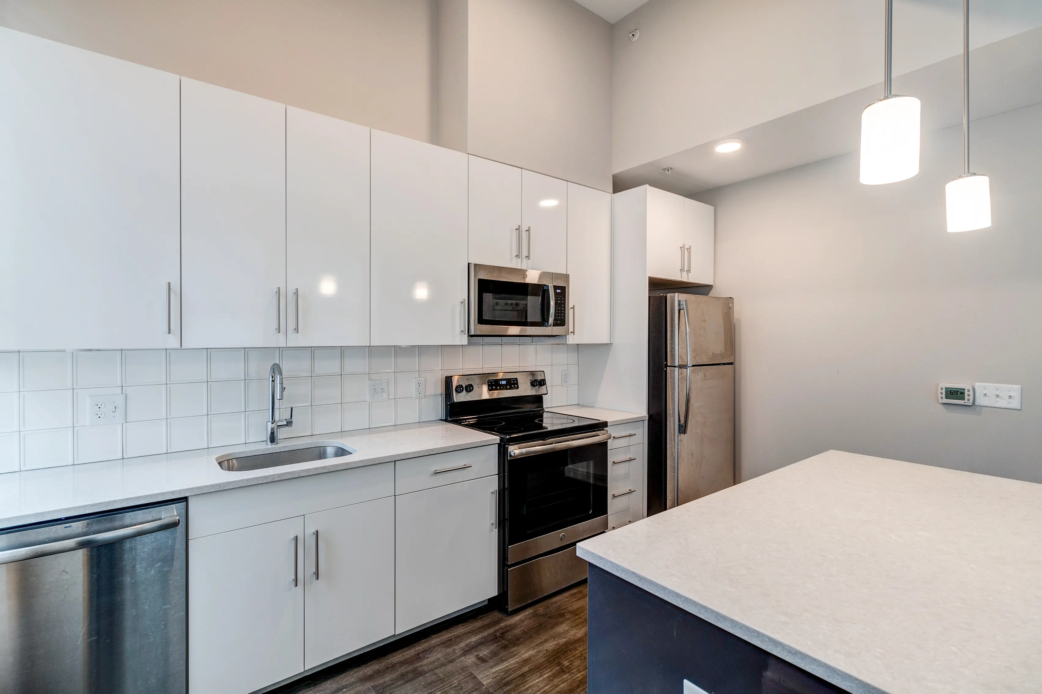 Contemporary Kitchen Design A modern kitchen featuring white cabinetry, stainless steel appliances, and a large countertop island with pendant lighting.