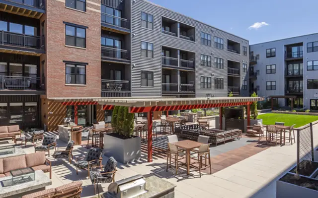 Outdoor communal space of a modern apartment complex with seating and landscaping.
