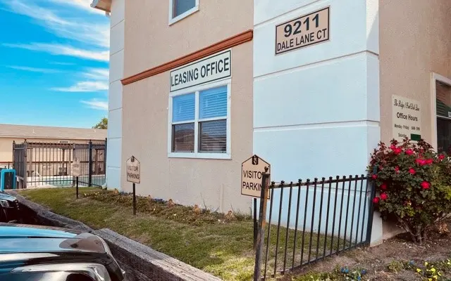 Exterior view of a leasing office building with a sign that reads 'Leasing Office' and an address of '9211 Dale Lane Ct'.