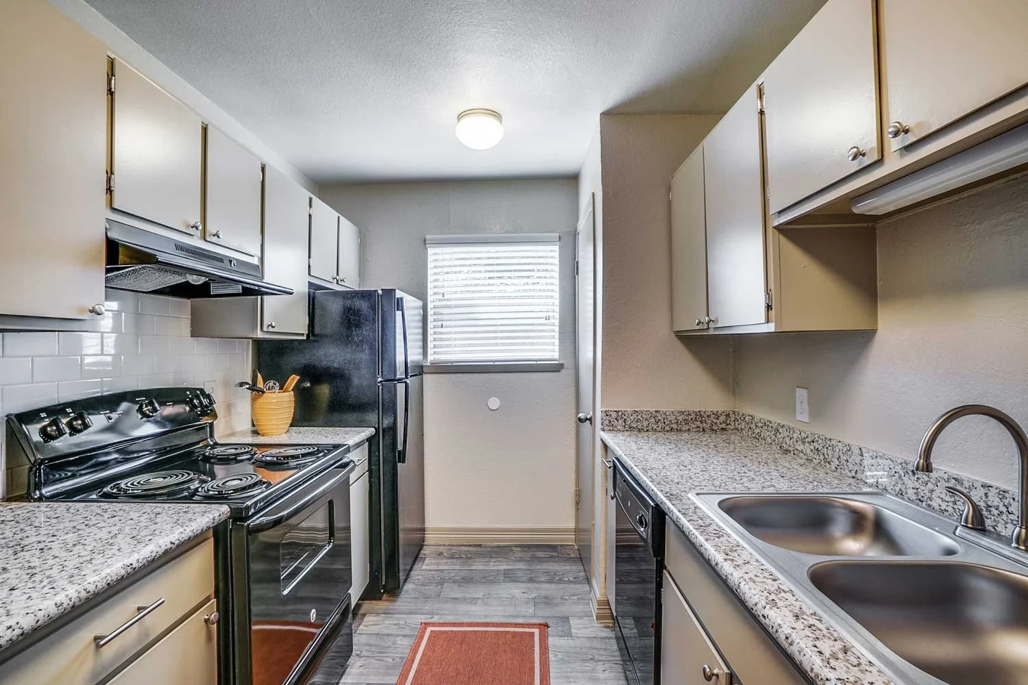 Modern kitchen interior with granite countertops and white cabinets.