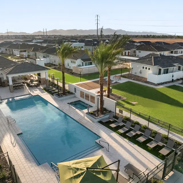 Community Swimming Pool Area An aerial view of a swimming pool area surrounded by residential houses and green lawns.