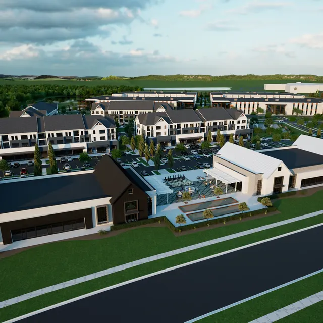 Aerial view of a modern mixed-use development featuring residential and commercial buildings, surrounded by green landscaping and paved pathways.