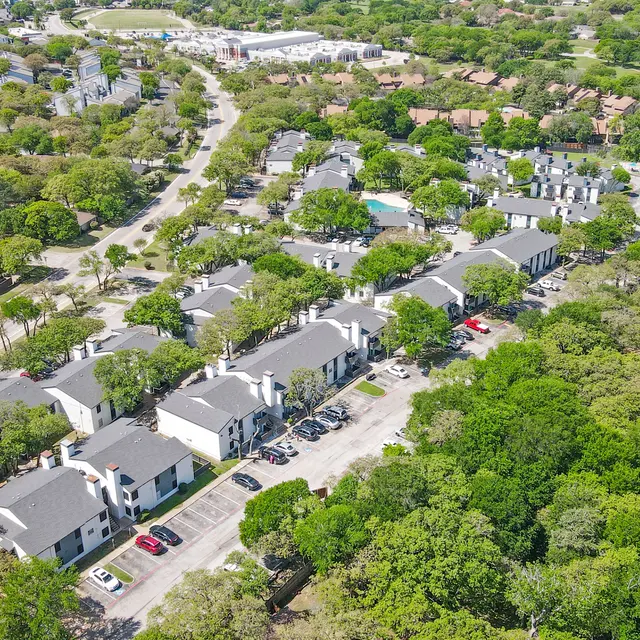 Aerial view of a suburban neighborhood featuring residential buildings and trees.