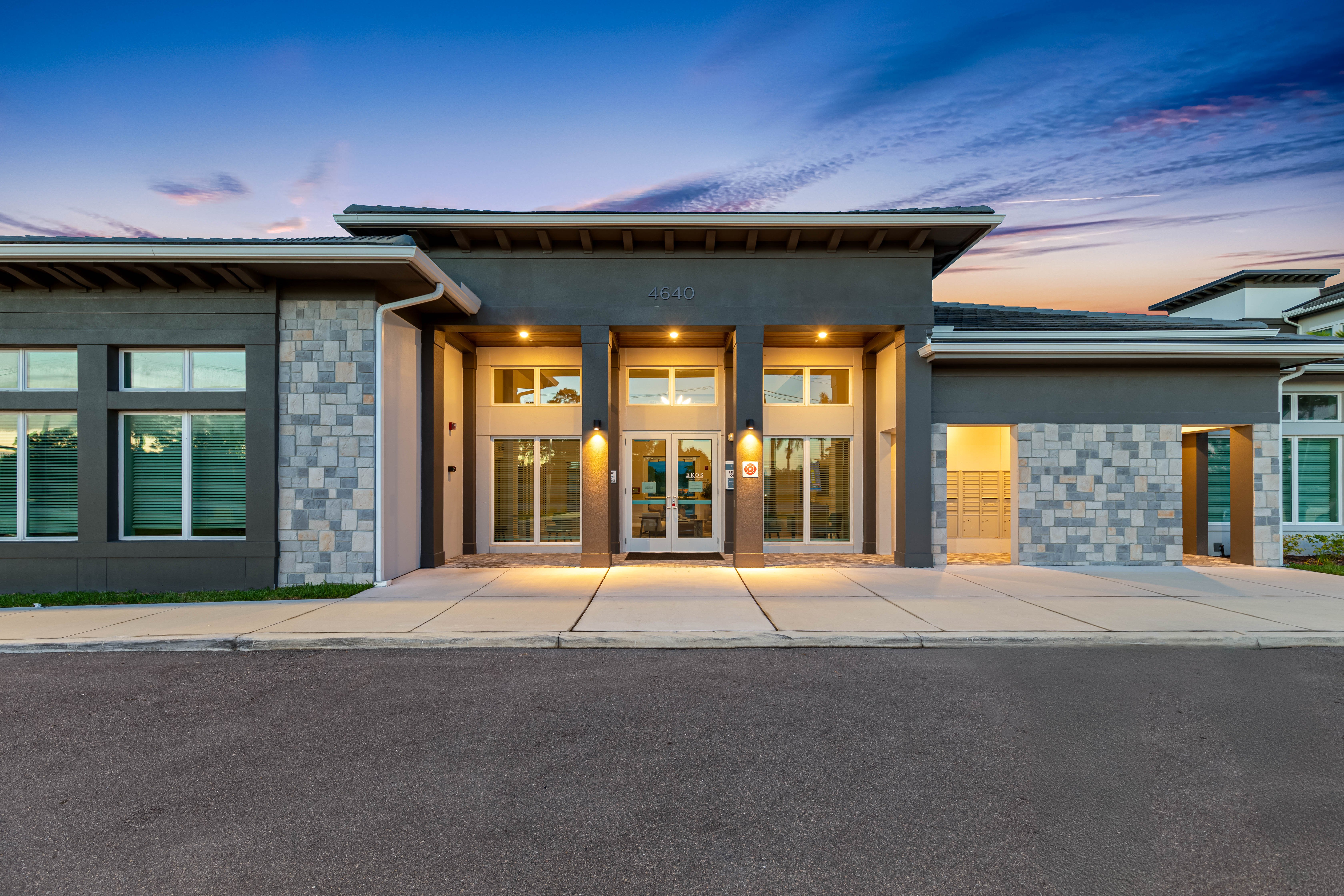Twilight View of a Modern Home Front view of a modern home featuring large entry doors and stone accents under a twilight sky.