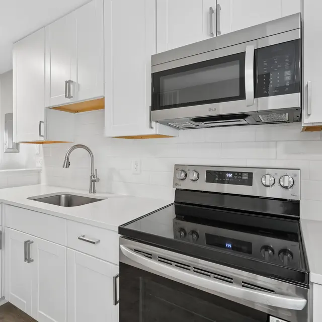 A modern kitchen featuring white cabinetry, stainless steel appliances, and a clean countertop design.