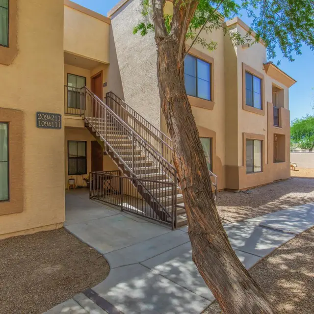 Residential Apartment Complex Exterior view of a residential apartment building with a staircase and landscaping.