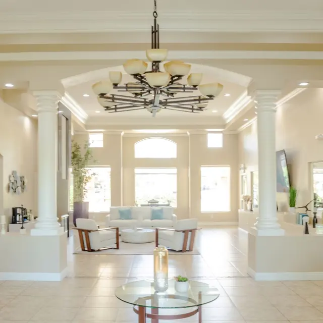 A spacious, modern interior with high ceilings, elegant lighting, and an open layout featuring a living area and dining space.