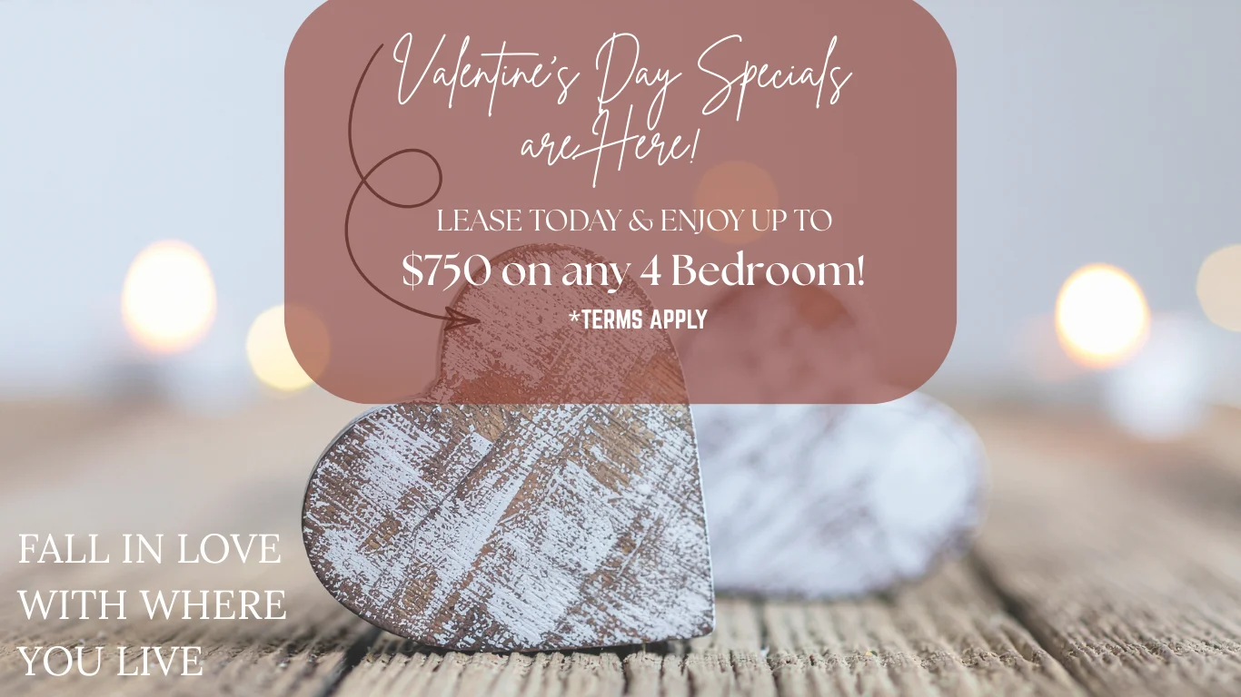 Promotional image for Valentine's Day apartment leasing specials, featuring a rustic wooden heart decoration and soft background lights.