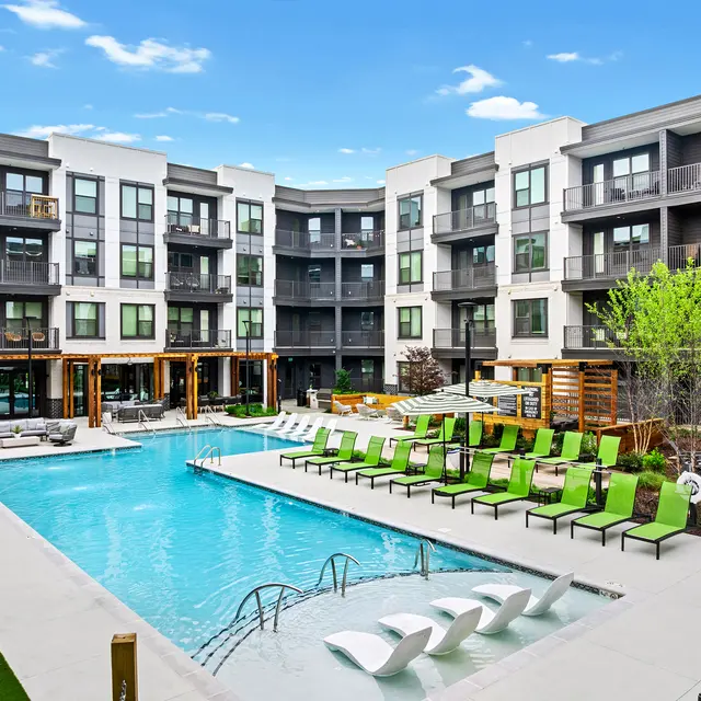 Modern Apartment Community Pool Modern apartment community pool area with lounge chairs and greenery.