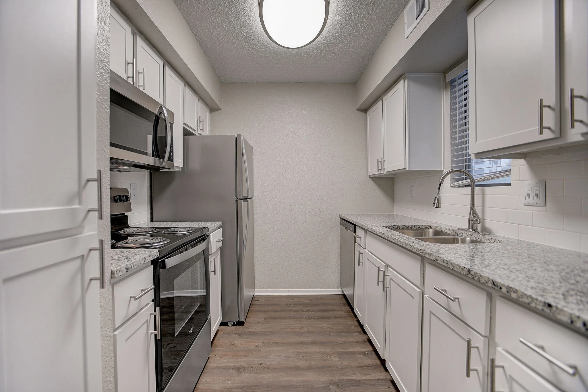 Stylish Modern Kitchen A modern kitchen featuring white cabinetry, stainless steel appliances, and granite countertops.