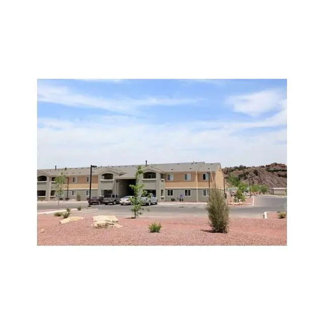Residential Apartment Complex View of a residential apartment complex with a parking area and desert landscaping.