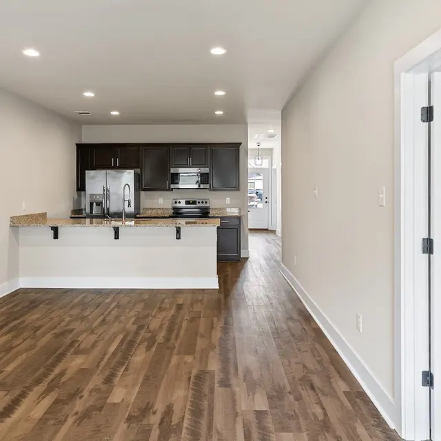 Modern Apartment Interior Modern interior of an apartment featuring an open layout, wooden flooring, and a kitchen area with dark cabinetry.