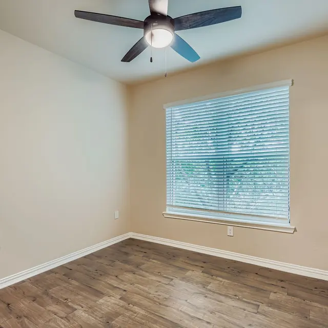 Empty Room with Ceiling Fan An empty room featuring a ceiling fan and a window with blinds