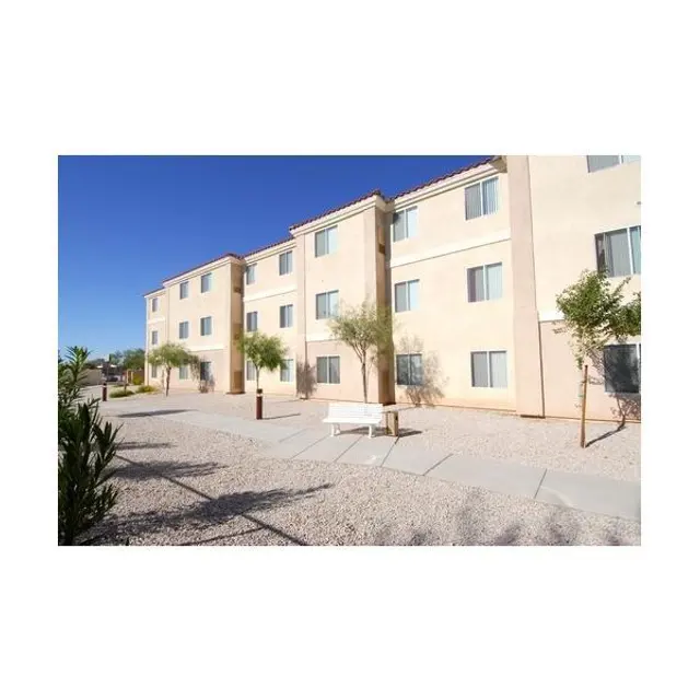 Apartment Complex Exterior Exterior view of a two-story apartment building with multiple windows, surrounded by low shrubs and a path