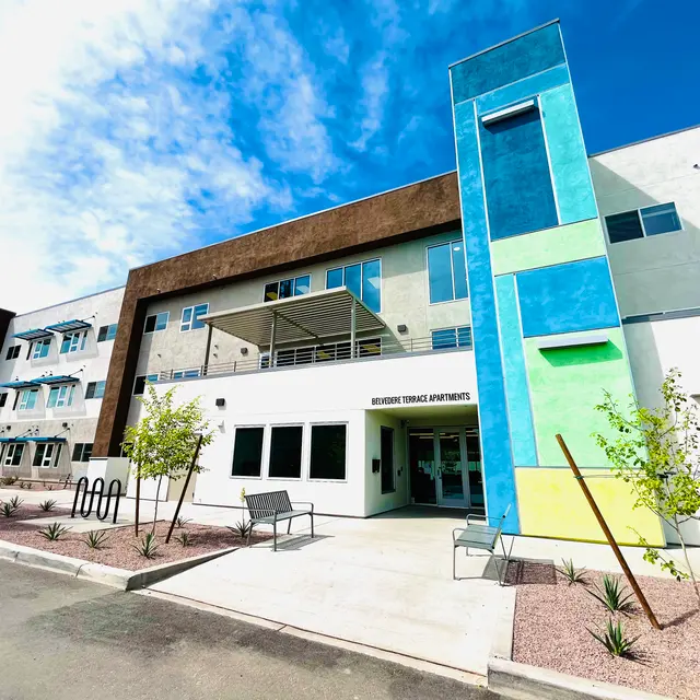 Exterior view of Modern Terrace Apartments showcasing a multi-story building with colorful accents and landscaped surroundings.