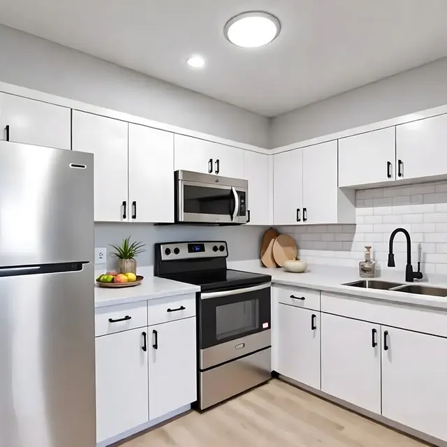 Modern kitchen with stainless steel appliances, white cabinets, and a clean countertop featuring fruit in a bowl.