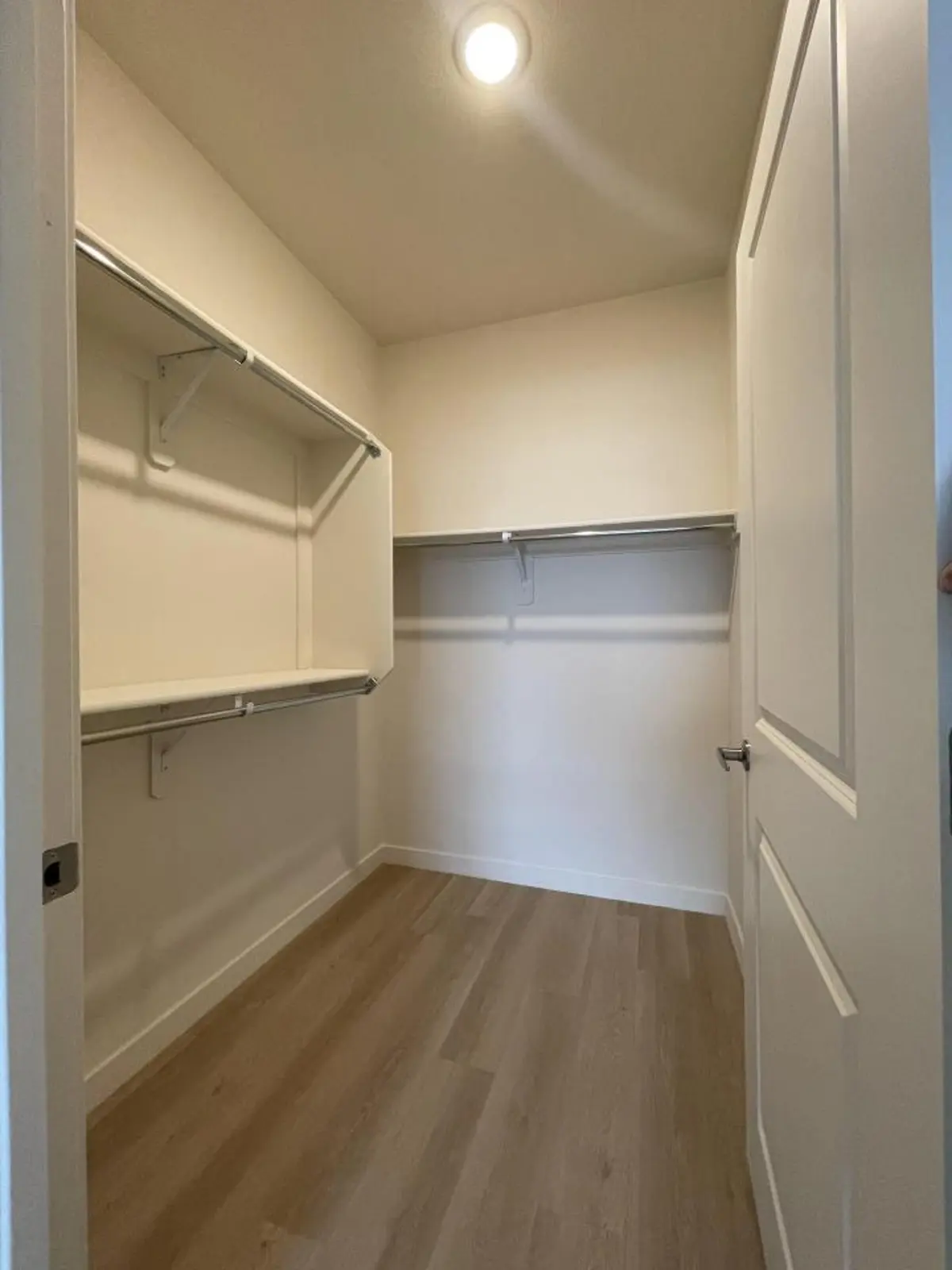 Walk-in closet with rails and shelves.