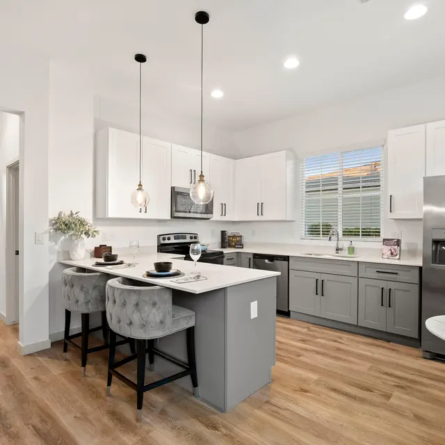 Modern kitchen with island seating and stainless steel appliances at The Farmhouse on Estrella