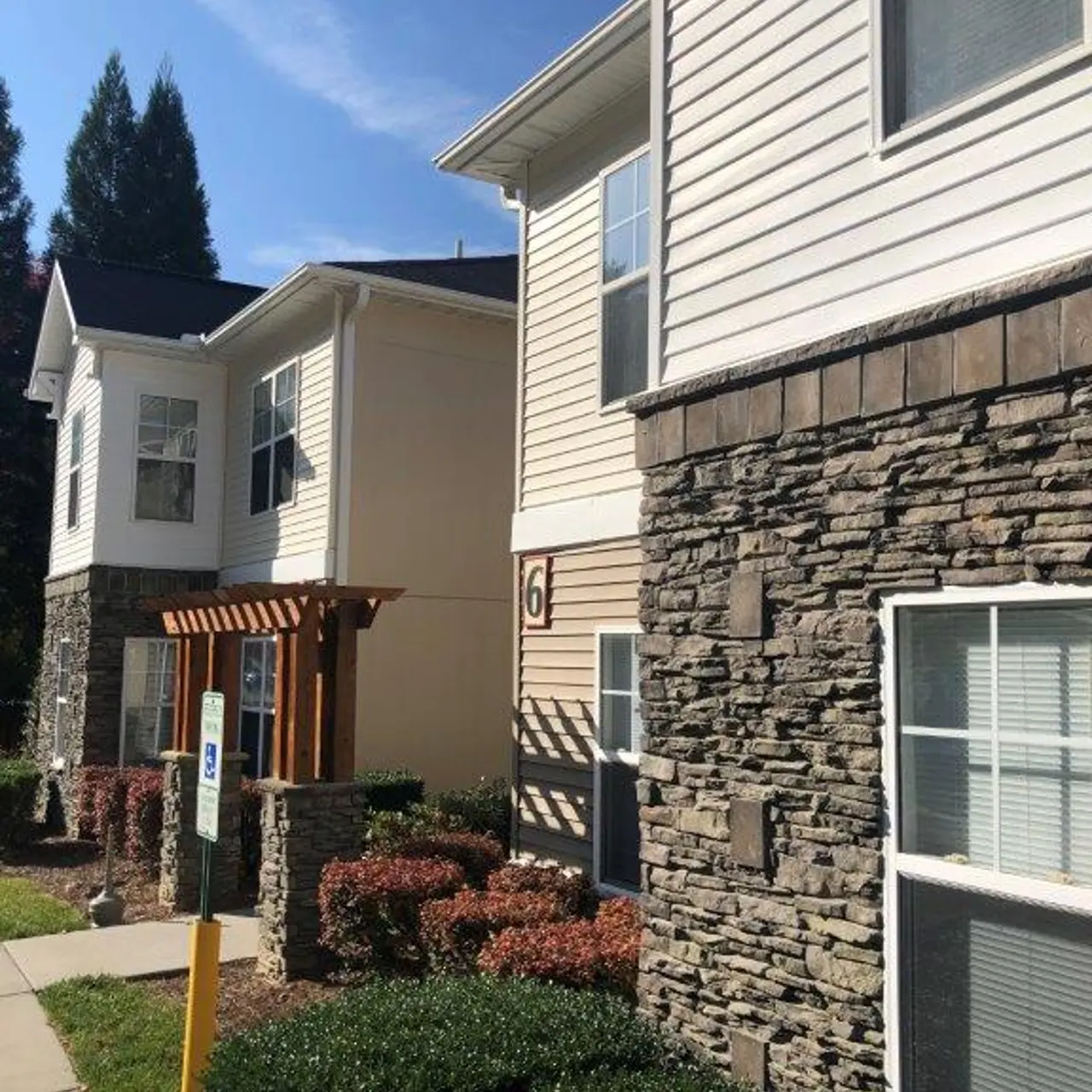 Exterior view of an apartment complex featuring stone accents and landscaped greenery.