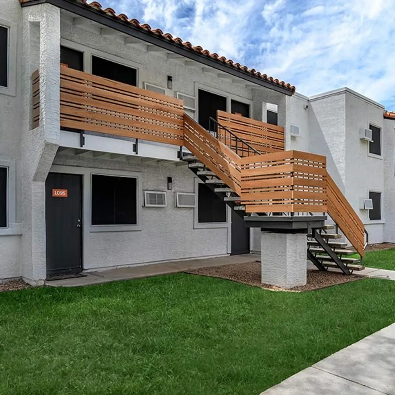 Exterior view of a multi-unit apartment building with wooden staircases and balconies