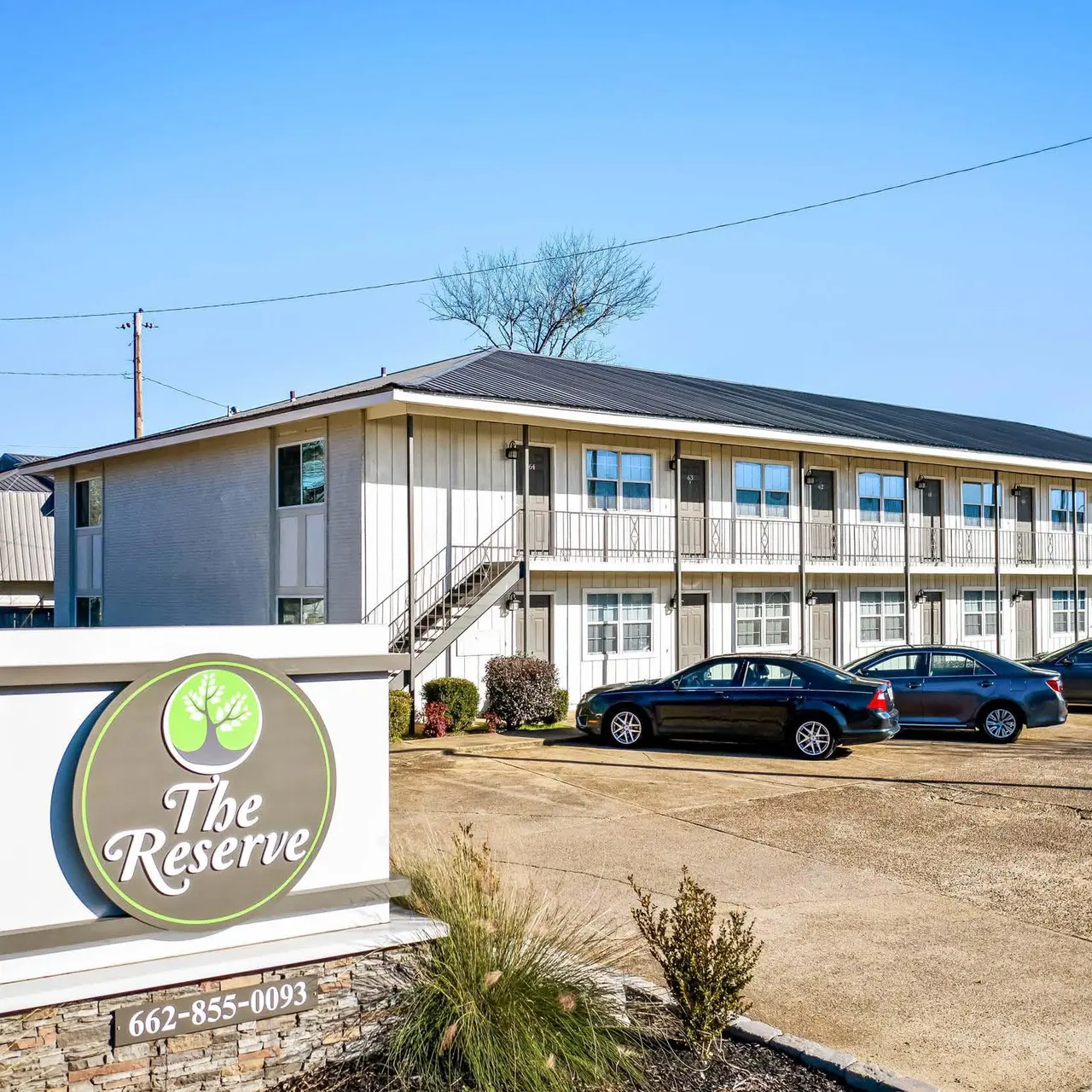 Haltere at Reserve - Exterior view of a low-rise apartment building with a sign that reads 'The Reserve'.
