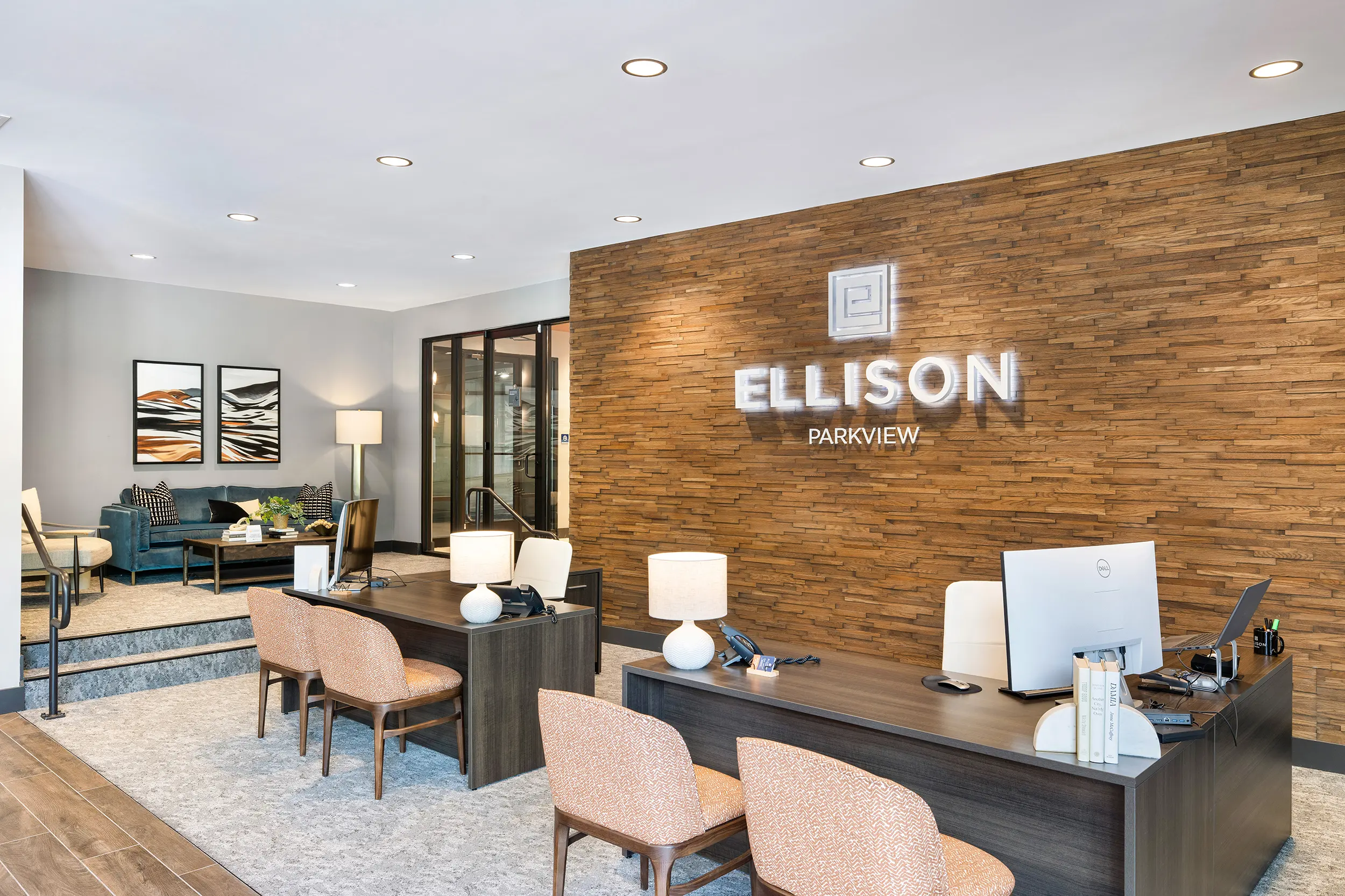 Reception Area of Ellison Parkview Modern reception area with two desks, a wooden accent wall, and seating in the background.