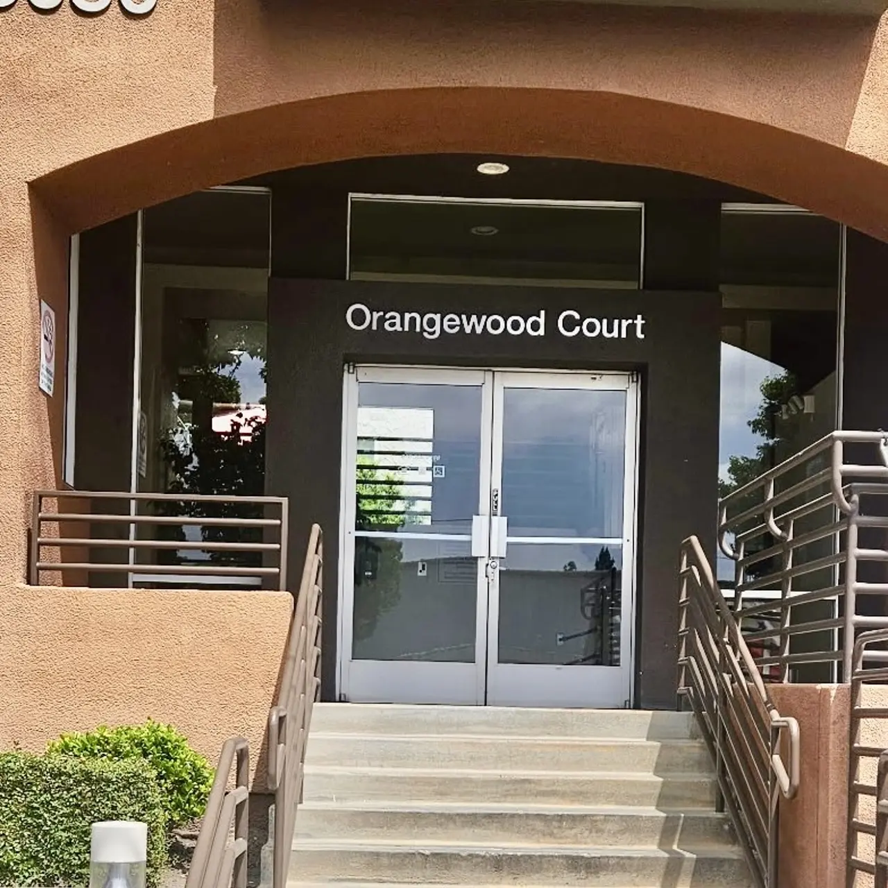 Entrance to Orangewood Court with a ramp and glass doors.