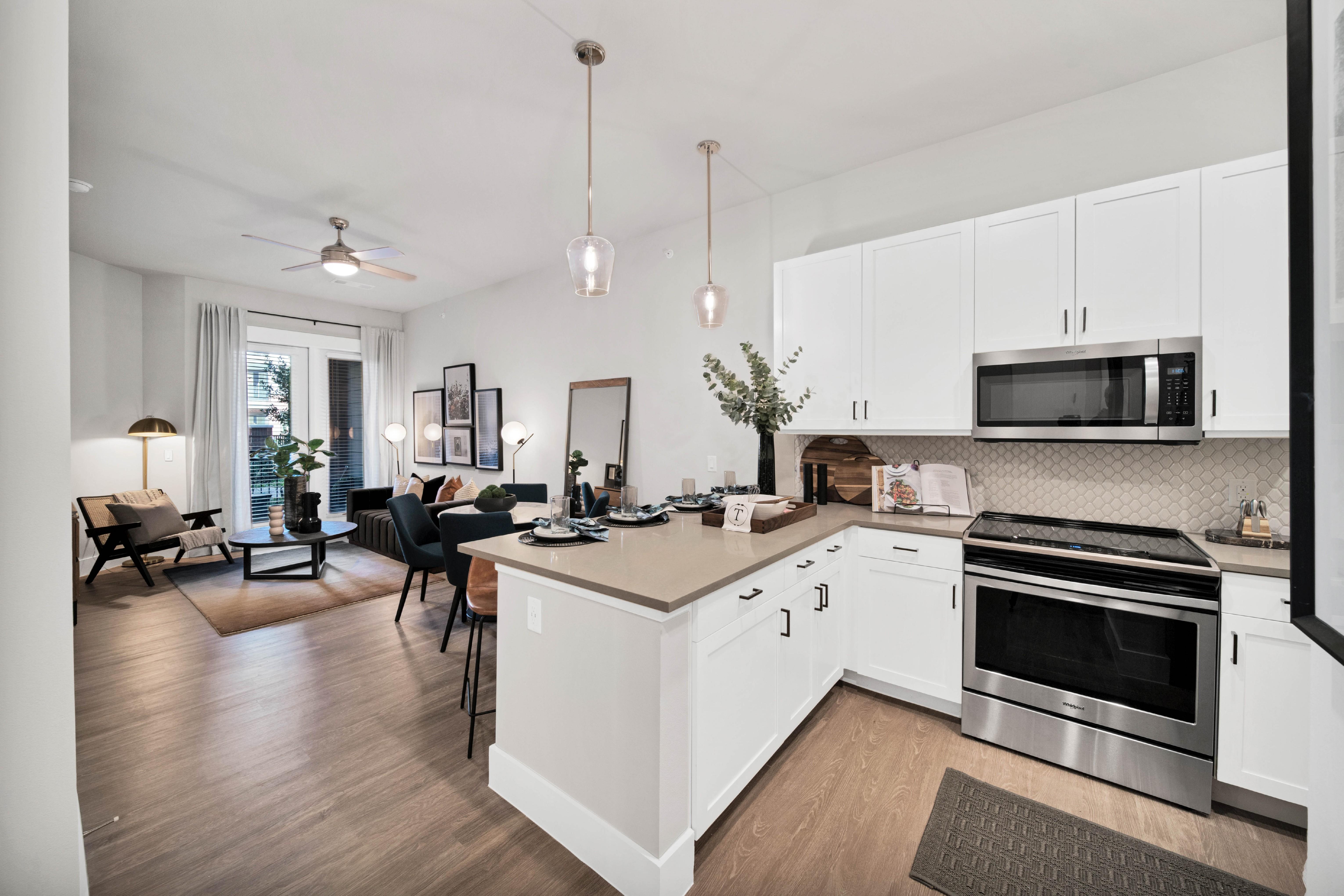 A modern apartment interior showcasing a kitchen and living area, featuring stylish furniture and decor.