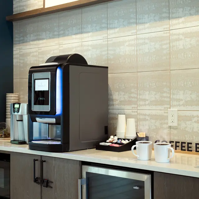 Modern Coffee Bar Setup A modern coffee bar setup featuring a coffee maker, mugs, and a neatly arranged tray with condiments.